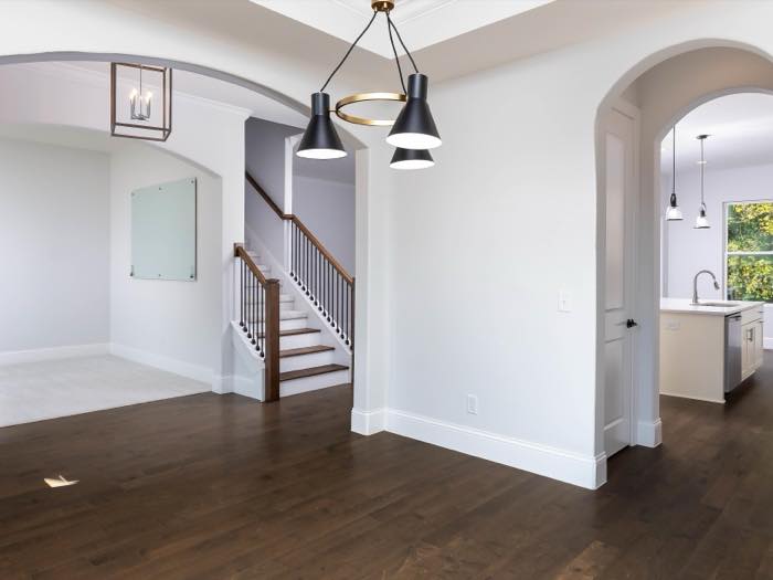 Arched openings connect dining, stair, and kitchen