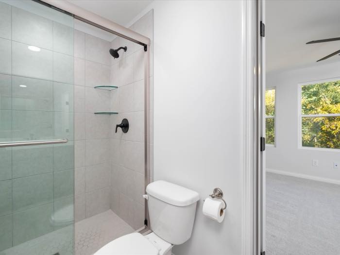 Tiled walk-in shower with a glass panel